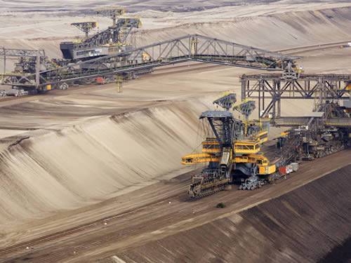 Machines are working in a mine lot in the picture, used to stand for mining industry.